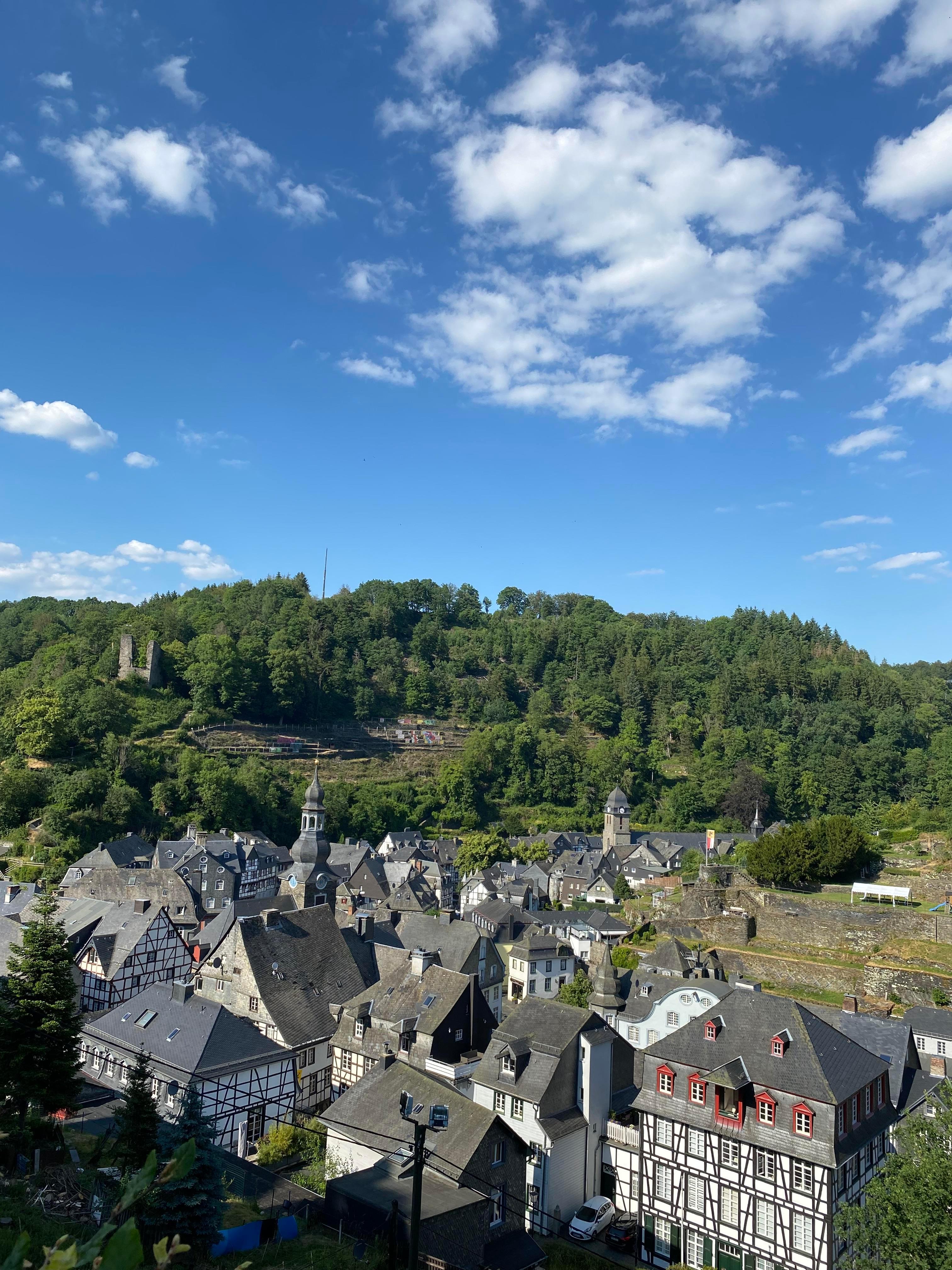 Monschau von oben Das Bild zeigt einen Blick auf die Stadt Monschau und die aus Bäumen und Wäldern bestehende Umgebung
